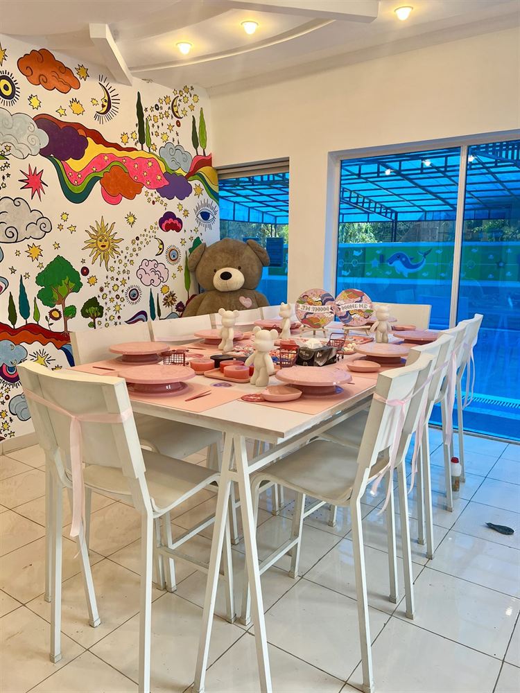 The Doodle Den studio in Gulberg 2, a table set for a workshop against the mural wall